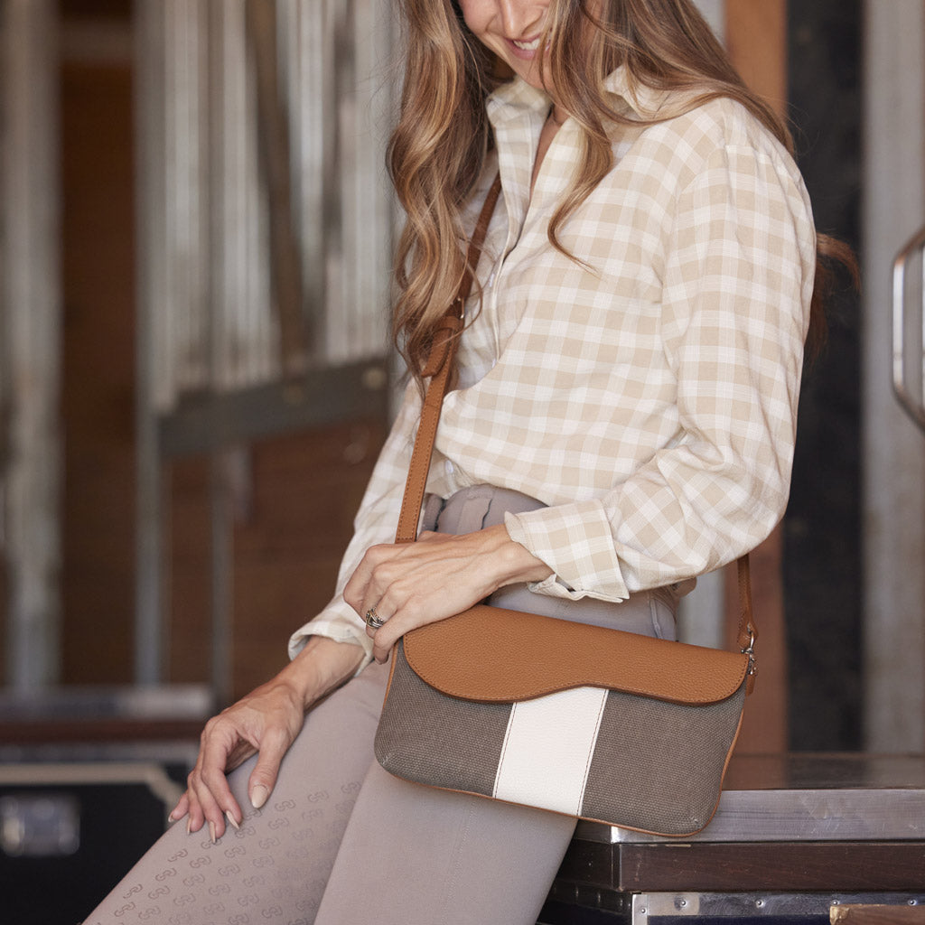 Equestrian holding Oughton's Paddock Crossbody Bag in Vintage Canvas